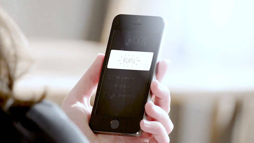 Smartphone mit Lern-Quiz zum Thema Hotellerie – richtige Antwort auf dem Bildschirm markiert.
