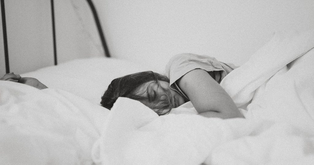 frau schlaeft in einem bett