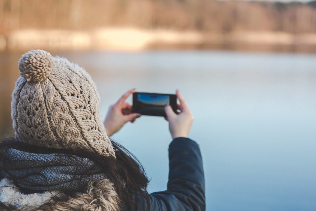 frau macht foto von stillem see
