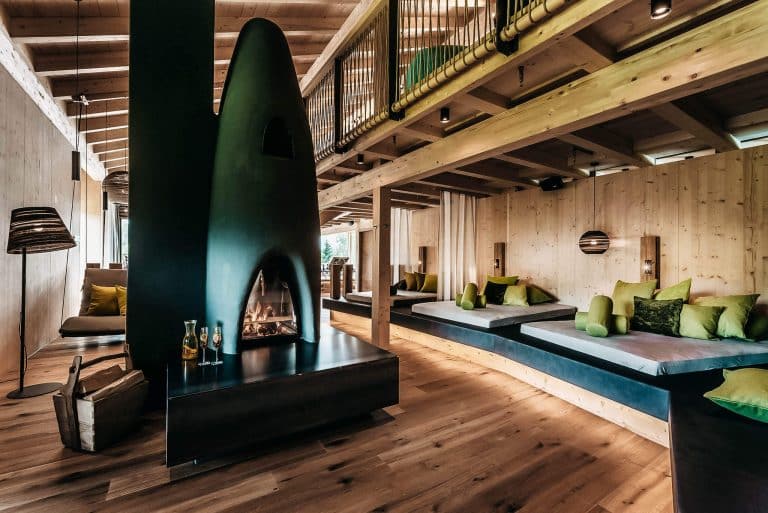 Stilvoll gestalteter Hotelbereich mit Holz, warmem Licht und Kamin als Beispiel für ein konsistentes Hotelkonzept mit klarem roten Faden